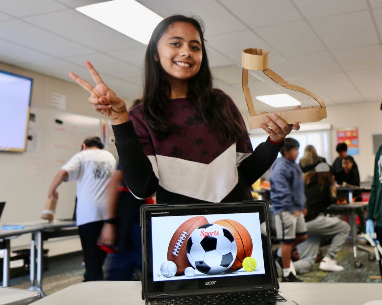 8th grade girl shows her design for an enhanced athletic shoe.