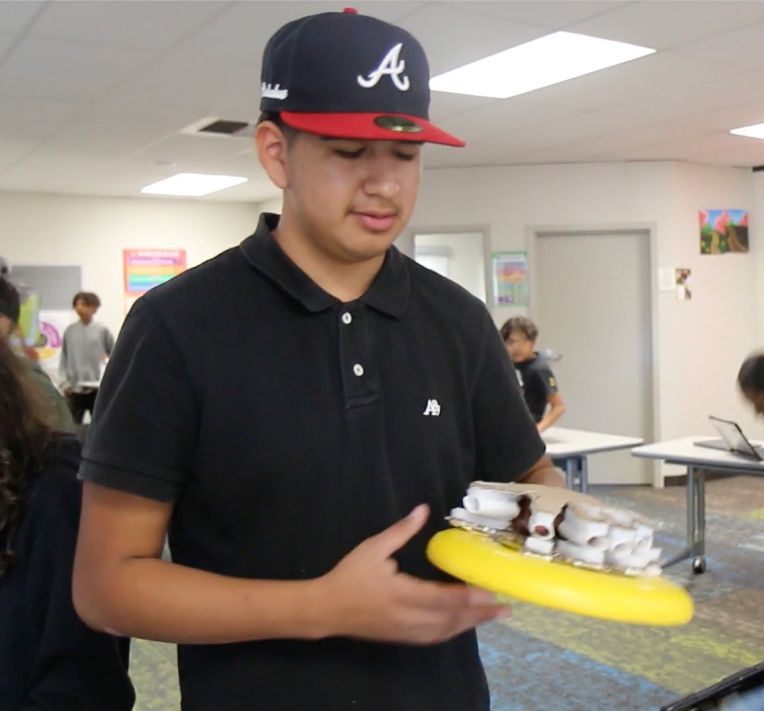 8th grade boy shows his design for a glove that enhances ball handling in sports