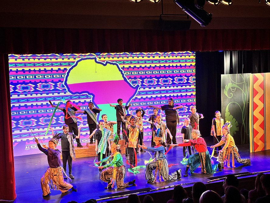 stage full of young students performing Lion King Jr.