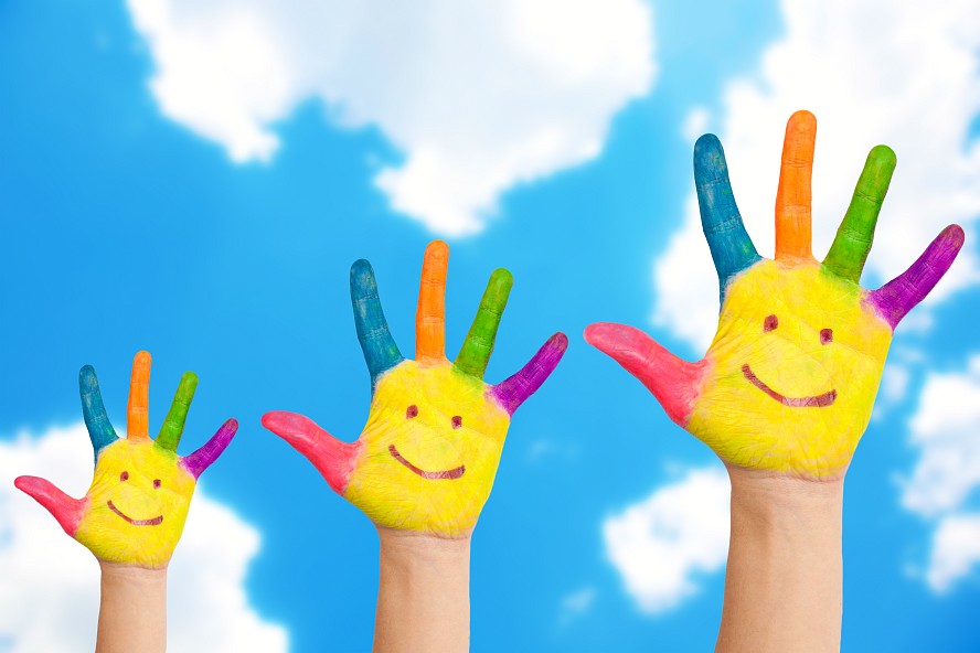 three raised hands with smiles painted on them