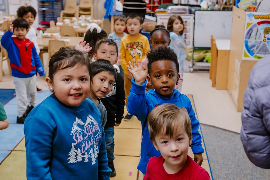 Preschool students at the Family Learning Center wave for the camera