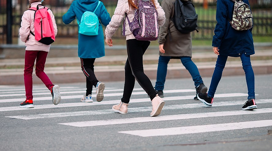 legs of students walking in a crosswa;l