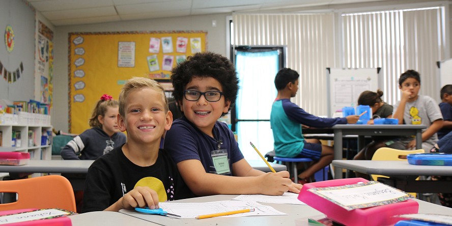 two boys in class smiling