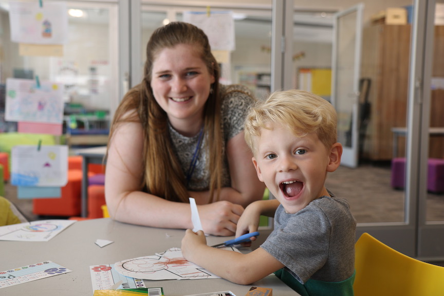 smiling kindergarten student with teacher