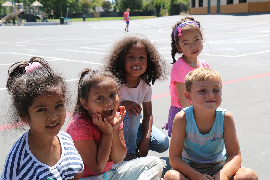 five elementary students smiling