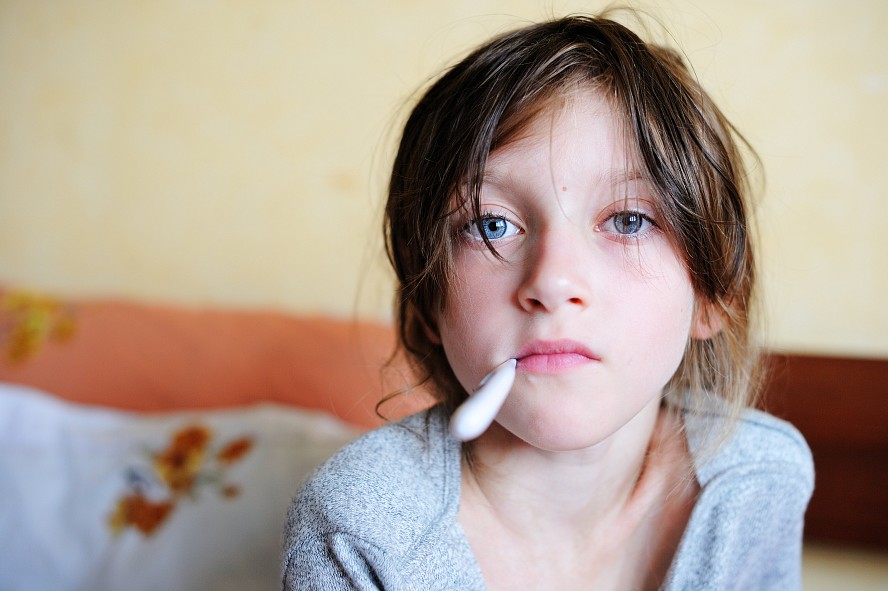 sick girl with thermometer in mouth