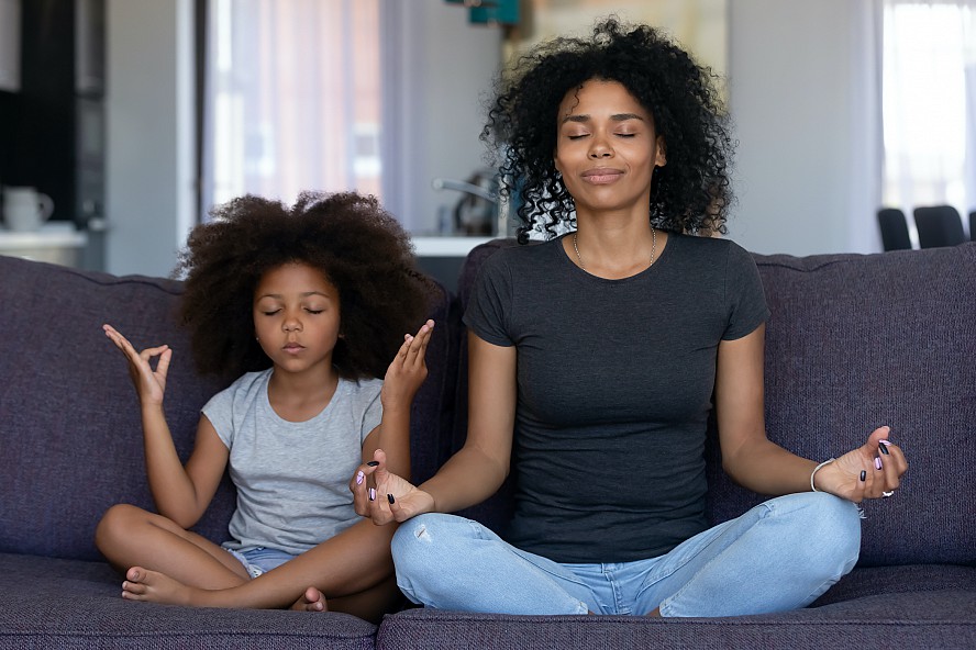 woman and girl sitting together meditating