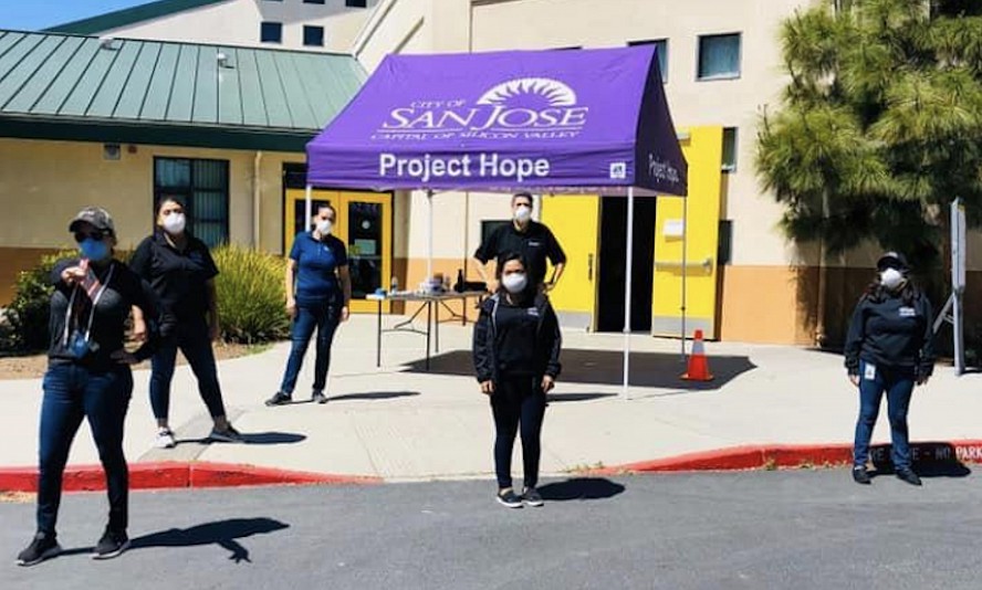 volunteers stand outside school