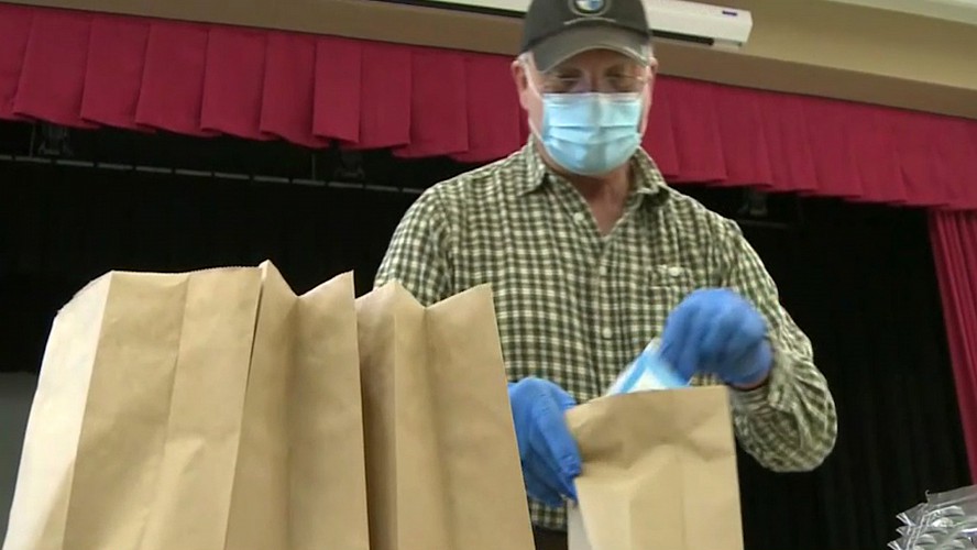 worker preparing to-go meals at school