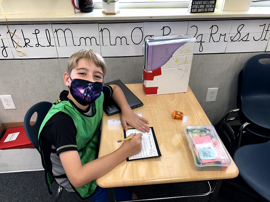 boy student smiling behind mask