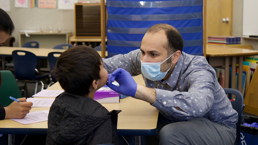 dentist checking young student's teeth