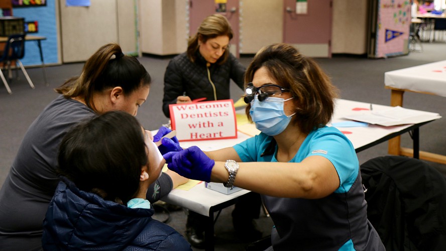 dentist checks a student's teeth