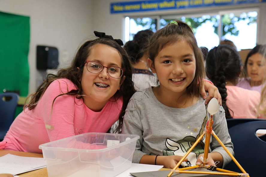 two girls smiling with their project