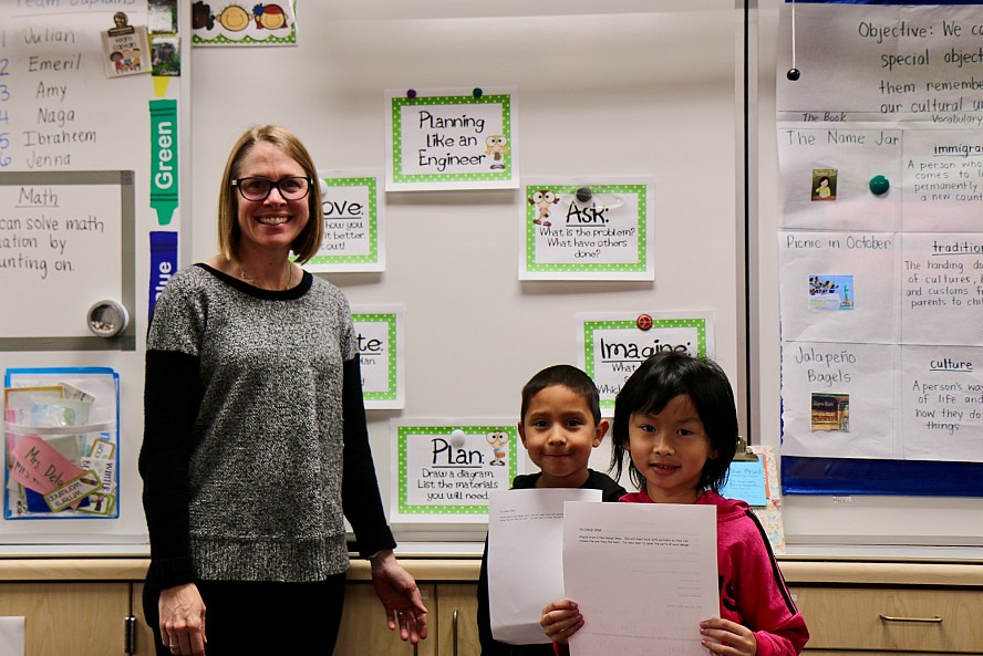 teacher at whiteboard with two students