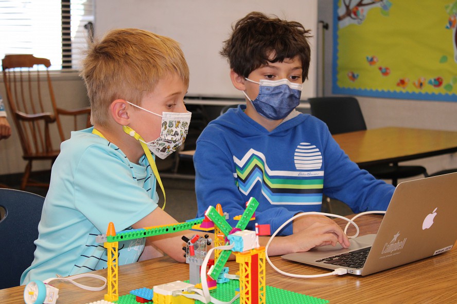 two boys work together on lego project