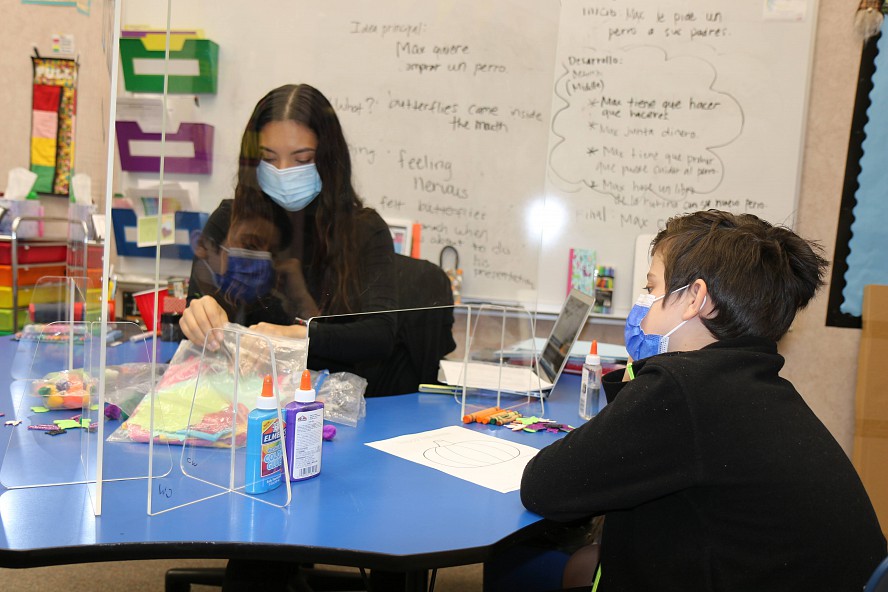 teacher works with young student