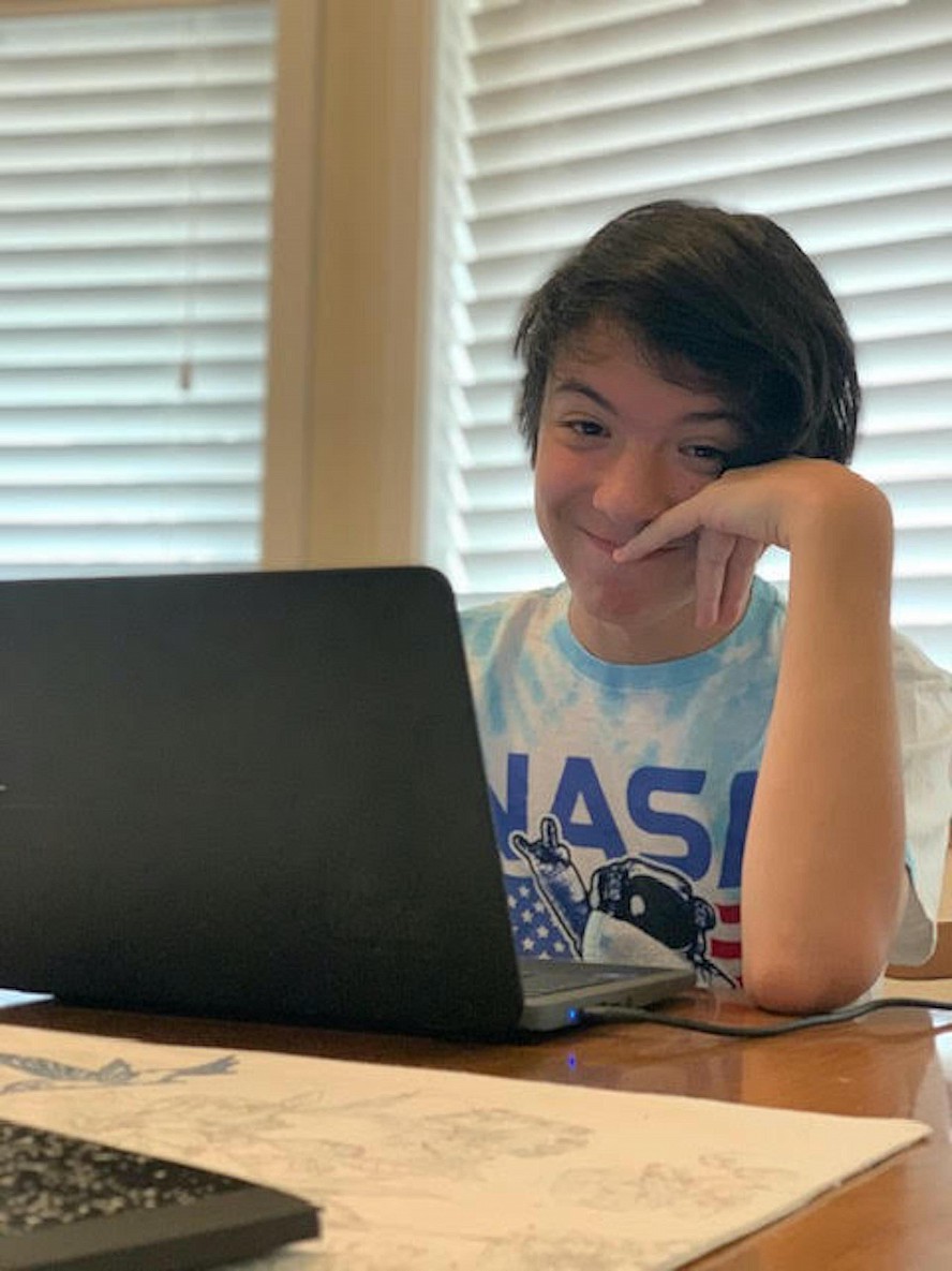 student smiling while working at laptop