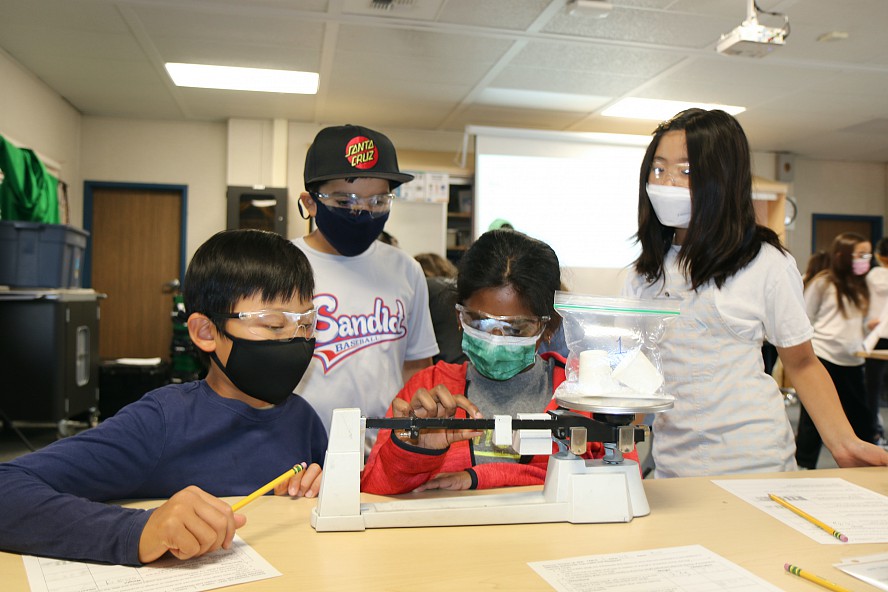 four students work an experiment at school