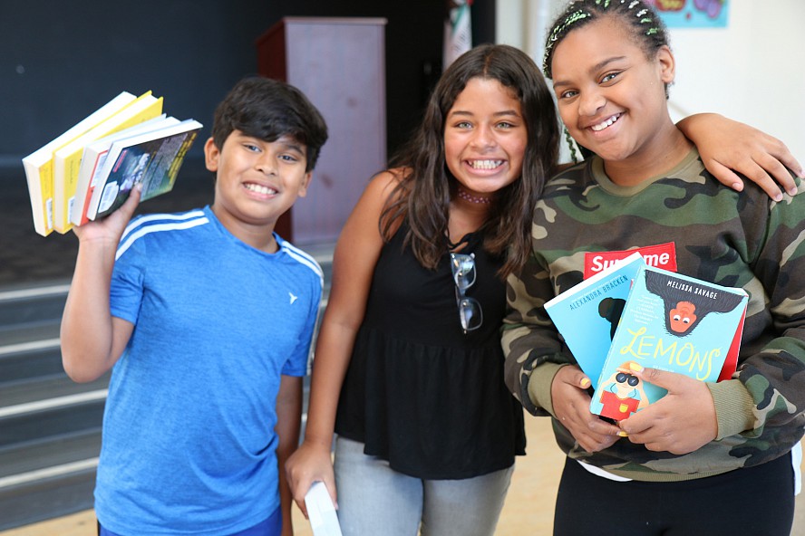 3 smiling students with books