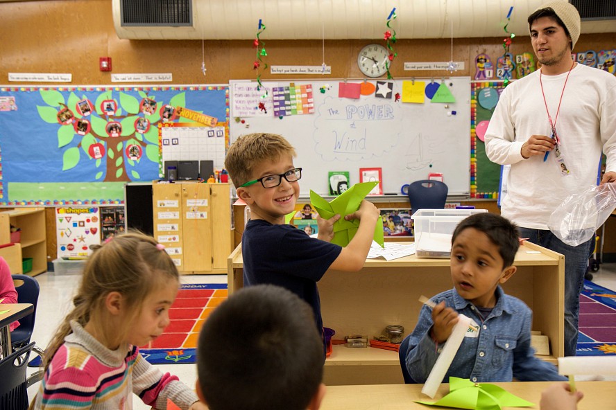 smiling boy shows the pinwheel he made