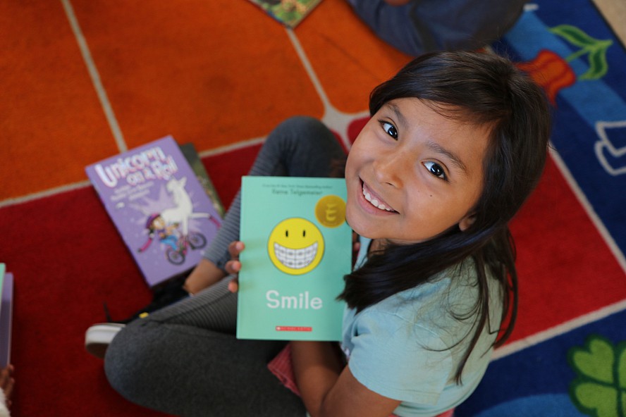 smiling girl on floor with book