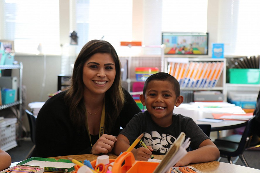 female teacher with young boy smiling at camera