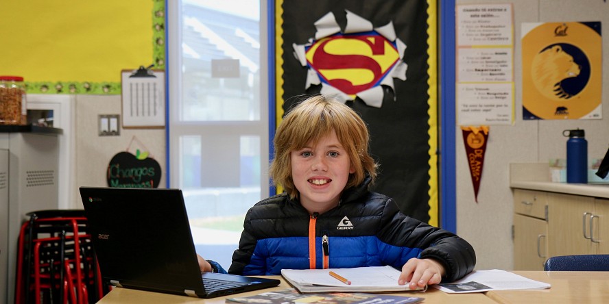 boy in school with superman symbol behind him