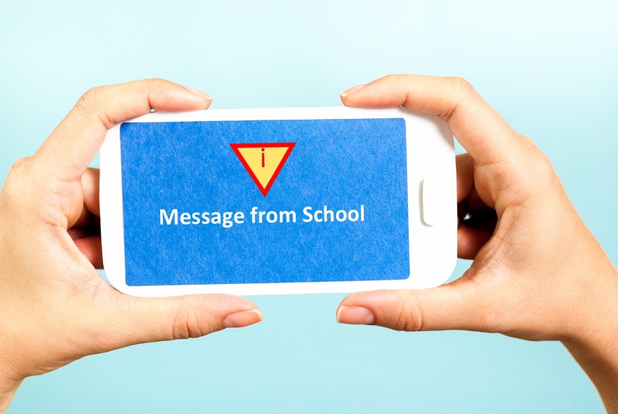 hands holding cell phone with message from school