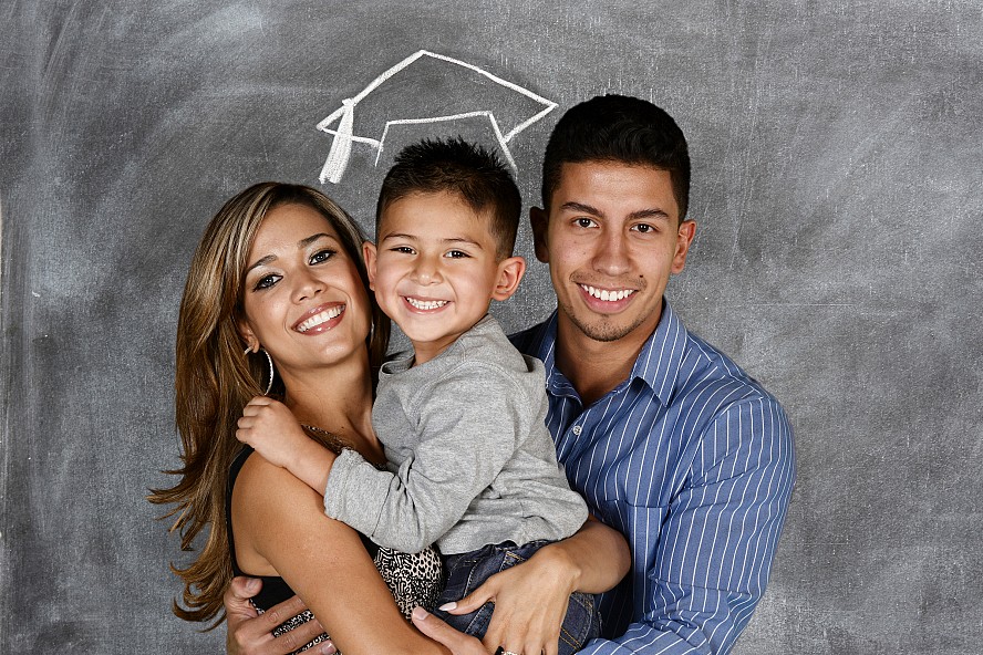 parents hold child with a graduation cap drawn above child's head