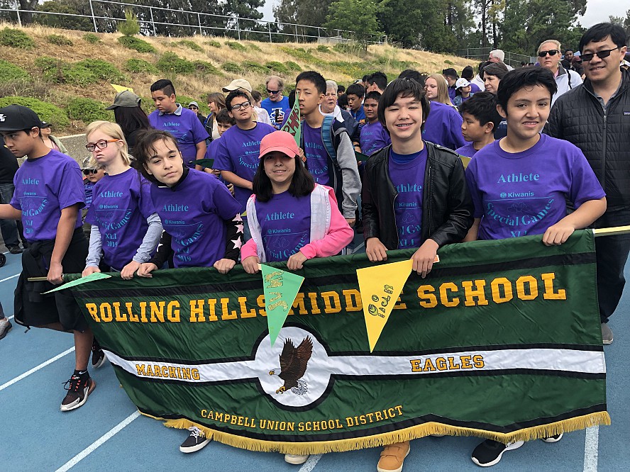 students hold banner at special games parade