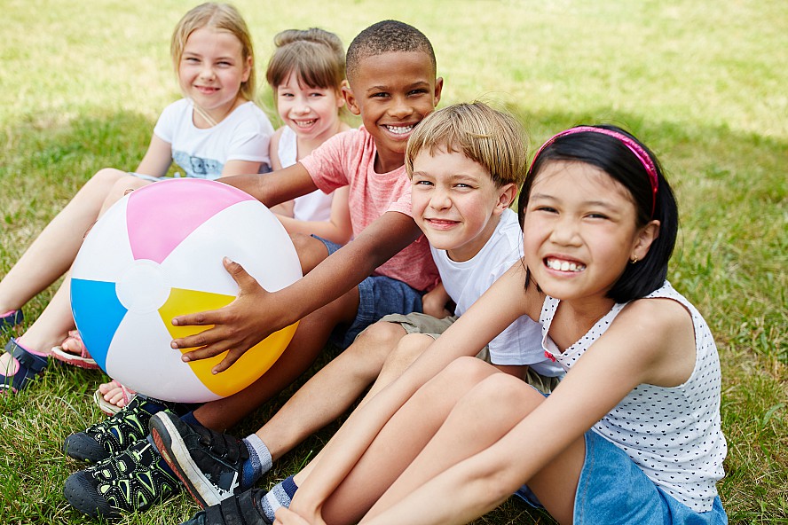 group of smiling children sitting on grass