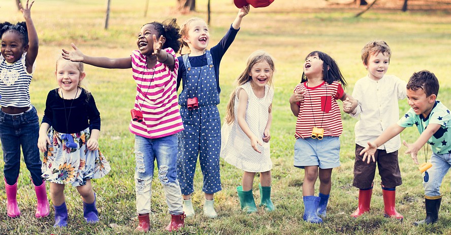 group of happy children in a grassy field