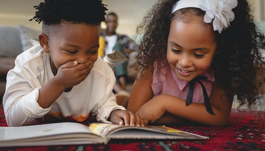 two children enjoying a book