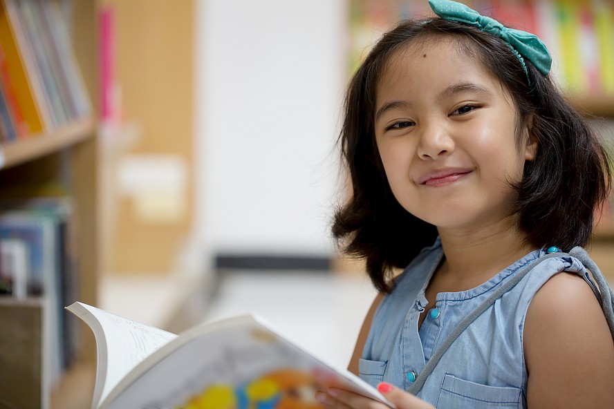 smiling girl outdoors with book 