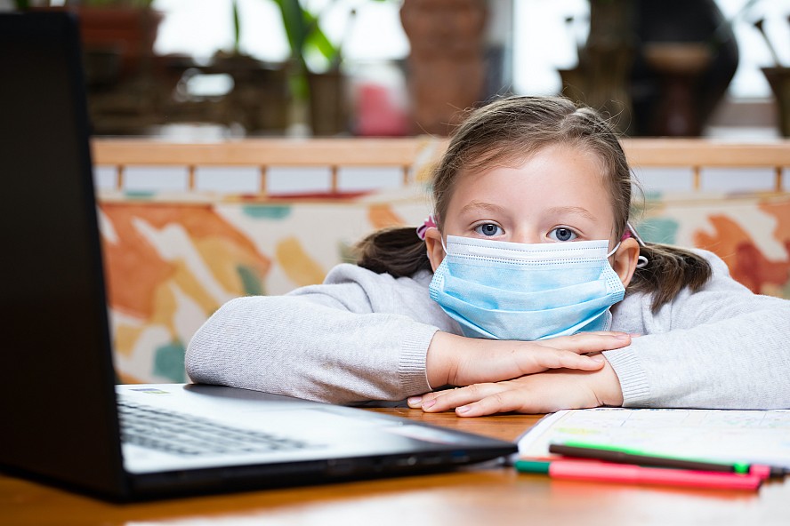 girl beside computer, wearing mask 