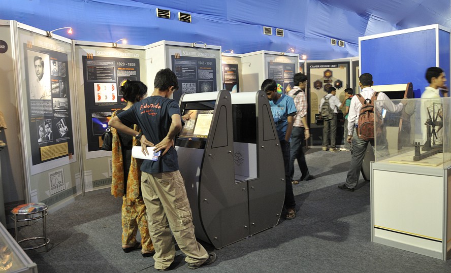 several students with backpacks interacting with technology exhibits