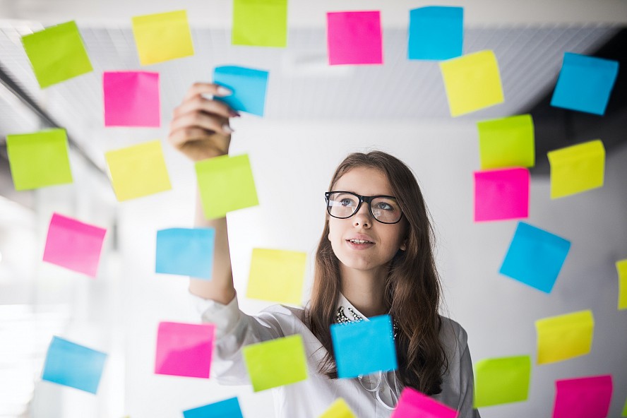 student choosing from a wall of post-it notes