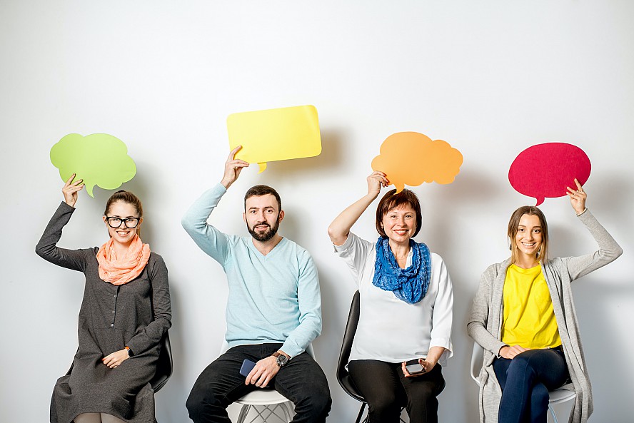 men and women holding thought bubbles over head