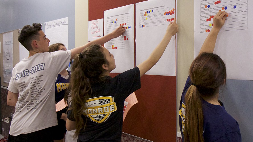 Students place stickers on posters