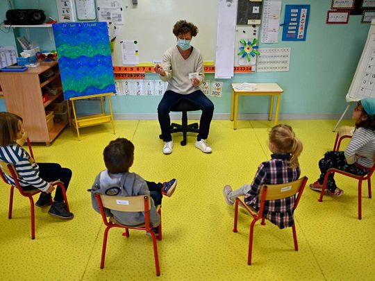 mask-wearing teacher with students 6-ft apart