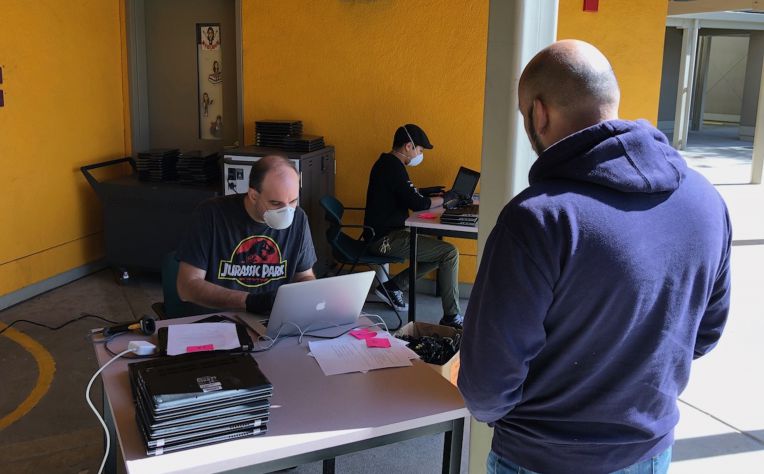 man waiting at table for chromebook checkout