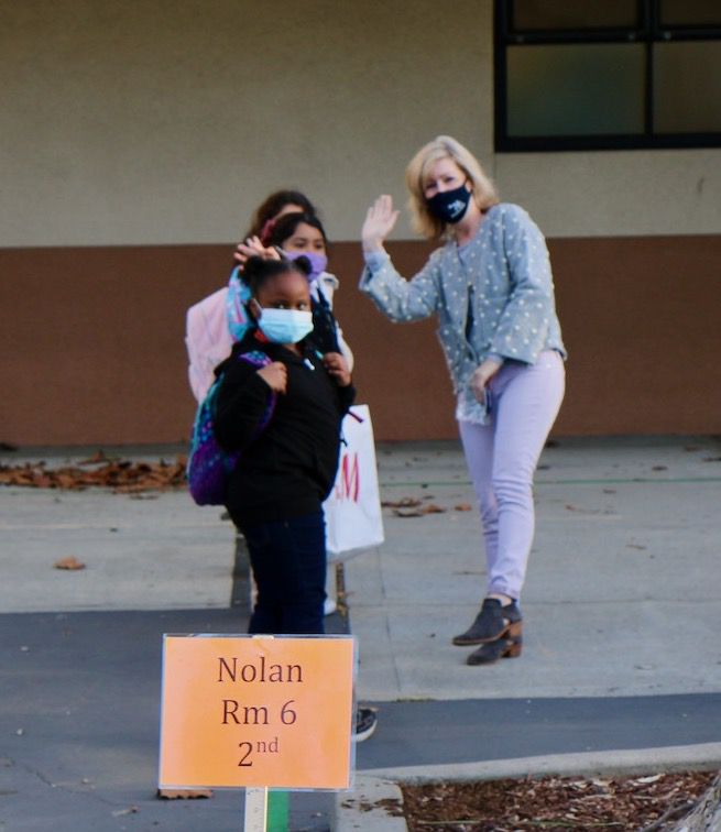 teacher waves as students line up