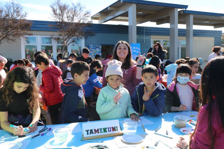 elementary children standing with female teacher