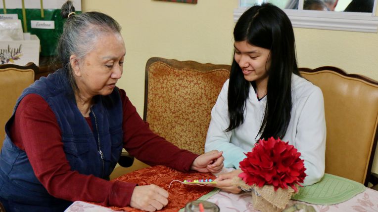 student helping senior citizen