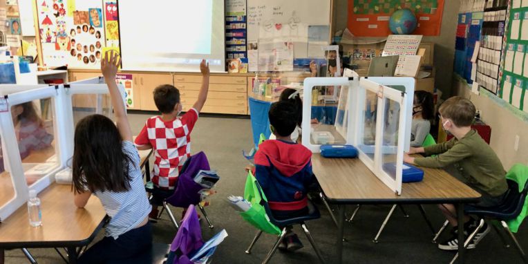 students at desks with dividers