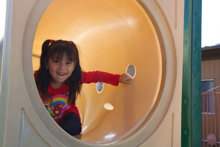 smiling girl in play tunnel