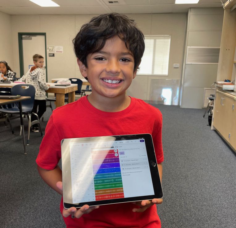 smiling boy holding ipad