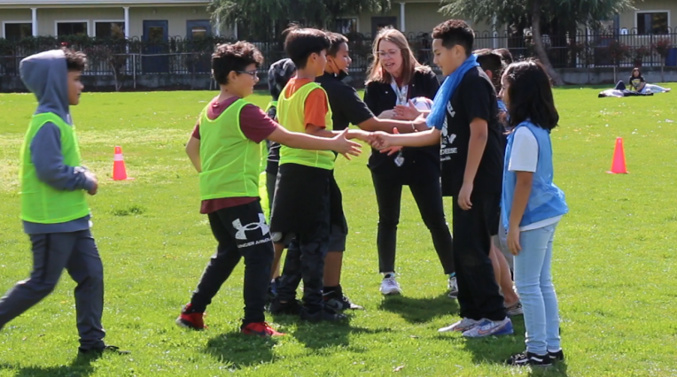 group of boys and girls shake hands before a soccer game