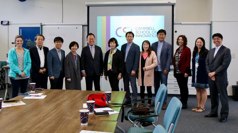 group of adults in front of CSI logo