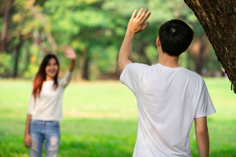 two youths waving to each other